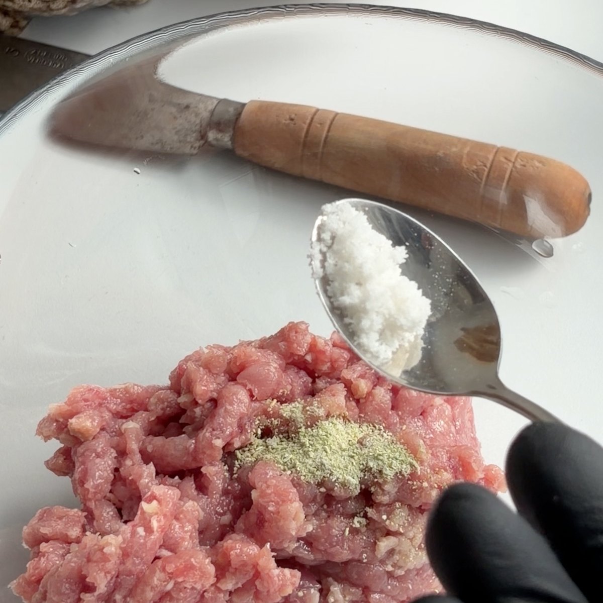 Os temperos sobre a carne picada, antes de amassar